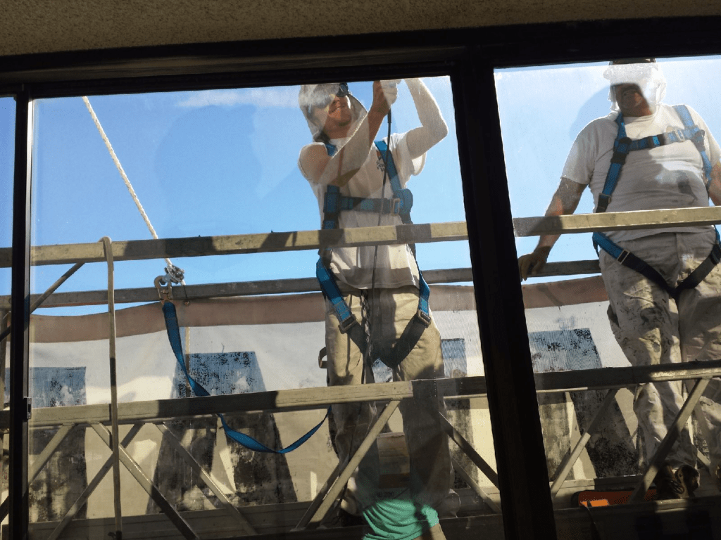 painters cutting out existing window caulk